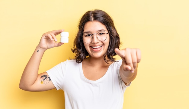 Jonge Spaanse vrouw wijzend op de camera die je ziektepillen concept kiest