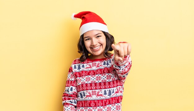 Jonge Spaanse vrouw wijzend op de camera die jou kiest. kerst concept