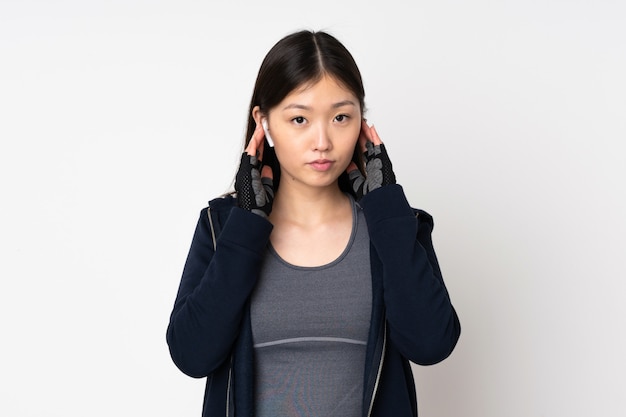 Jonge sport Aziatische vrouw op witte muur het luisteren muziek