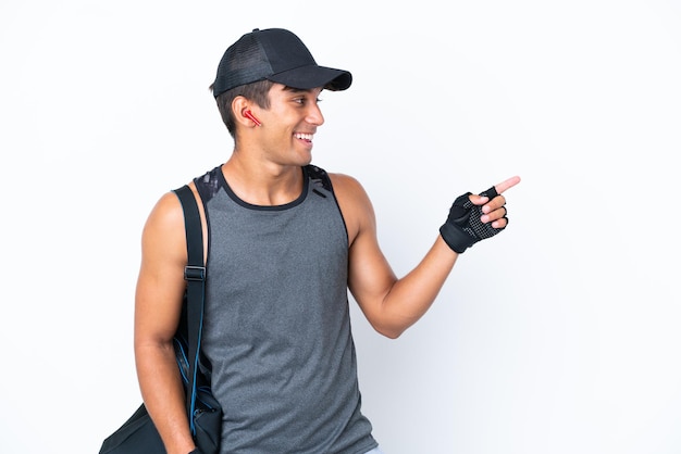 Jonge sport blanke man met sporttas geïsoleerd op een witte achtergrond wijzende vinger naar de zijkant en presenteren van een product