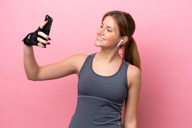 Jonge sport blanke vrouw geïsoleerd op roze achtergrond maken een selfie