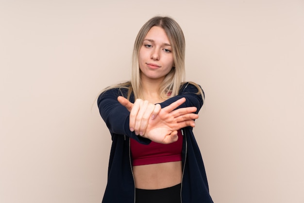 Foto jonge sport blonde vrouw het uitrekken zich wapen