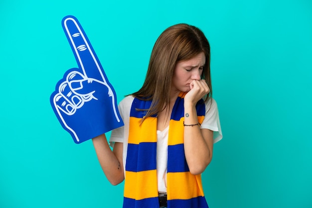 Jonge sportfan vrouw geïsoleerd op blauwe achtergrond met twijfels