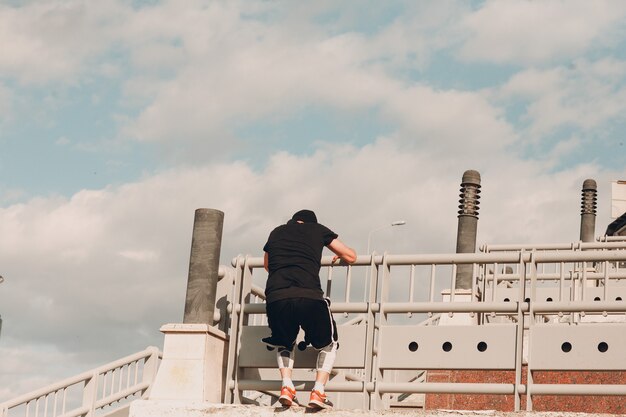 Jonge sportieve kerel die parkour doet bij de stadsstraat.