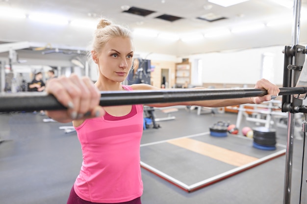 Foto jonge sportieve mooie blonde vrouw in de sportschool.