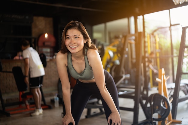 Jonge sportieve vrouw die zich uitstrekt op sportschool, fitness sport concept