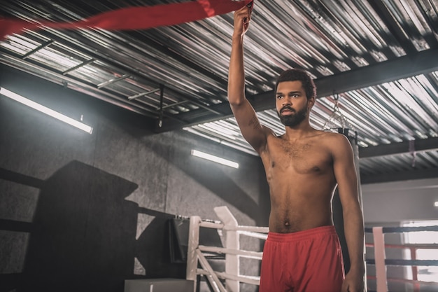 Jonge sportman. Donkere jonge sportman in een sportschool die zich klaarmaakt voor de training