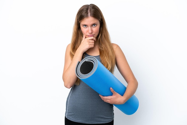 Jonge sportvrouw die naar yogalessen gaat terwijl ze een mat vasthoudt