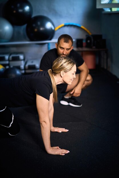 Jonge sportvrouw doet pushups tijdens de oefening
