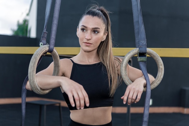 Jonge sportvrouw met ringen in gym