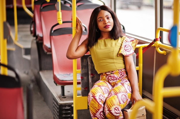 Jonge stijlvolle Afro-Amerikaanse vrouw rijden op een bus.