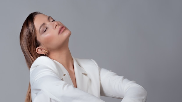 Jonge stijlvolle dame in een wit broekpakportret in de studio