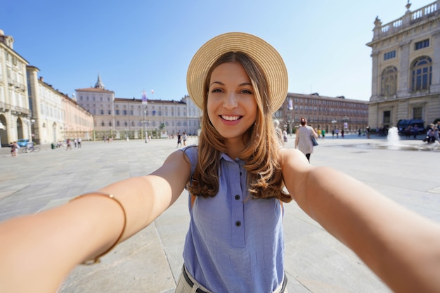 Jonge stijlvolle meid neemt selfie met mobiele telefoon op zomer stadsstraat stedelijke levensstijl concept