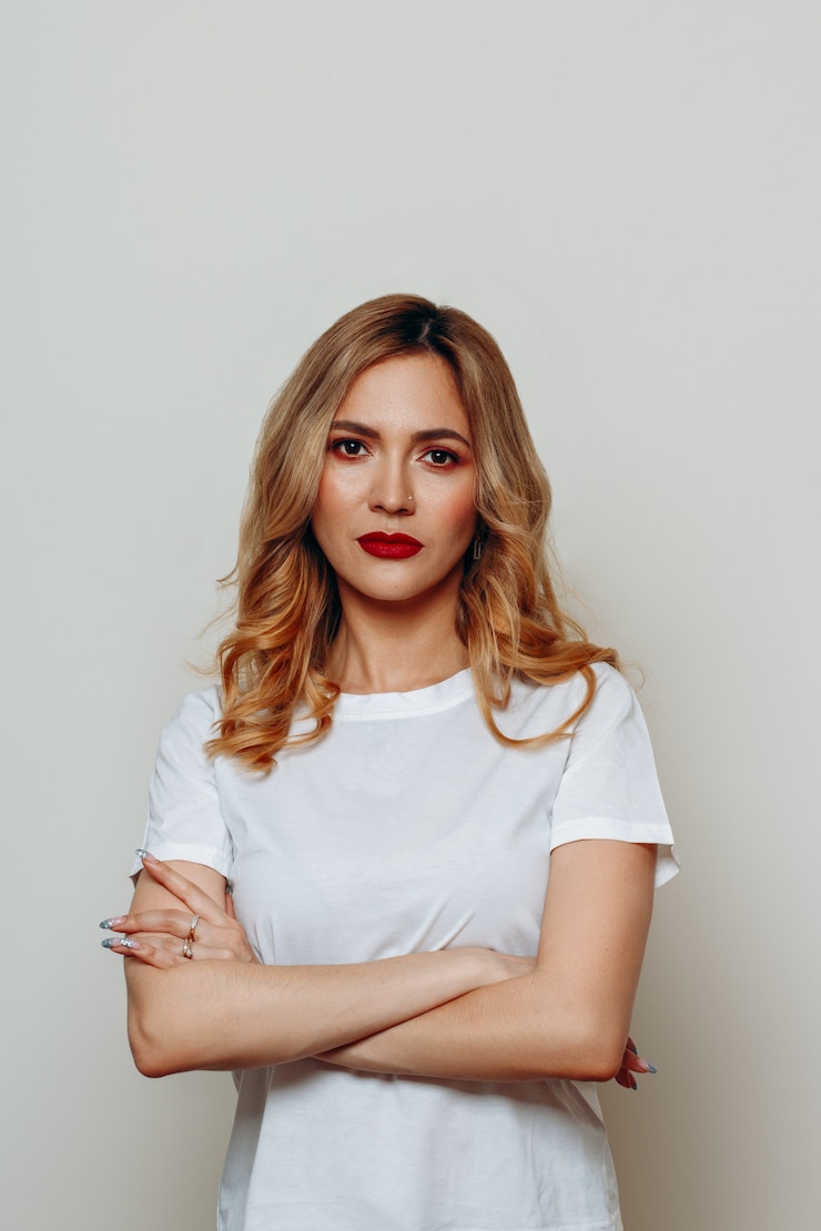 Foto jonge stijlvolle vrouw met rode lippen kijkt serieus op wit.