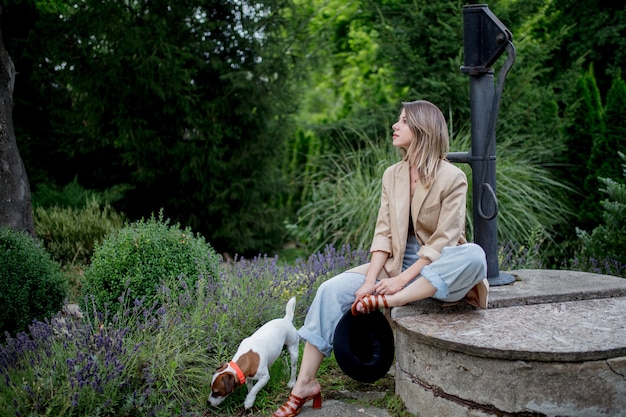 Jonge stijlvolle vrouw zitten in de buurt van lavendel bloemen in een tuin