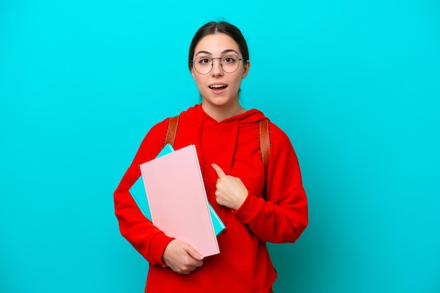 Jonge student blanke vrouw geïsoleerd op blauwe achtergrond met verrassing gezichtsuitdrukking