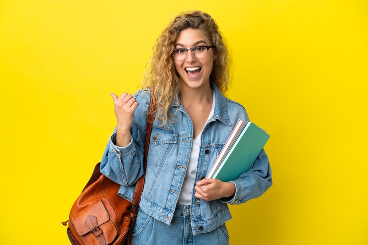 Foto jonge student blanke vrouw geïsoleerd op gele achtergrond wijzend naar de zijkant om een product te presenteren