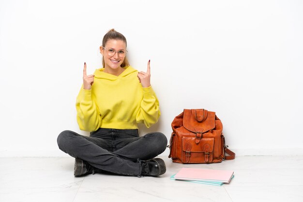 Jonge student blanke vrouw zittend op de vloer geïsoleerd op een witte achtergrond wijzend op een geweldig idee