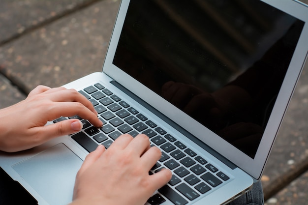 Jonge student die laptop in openlucht met behulp van.