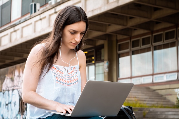 Jonge student die laptop in openlucht met behulp van.