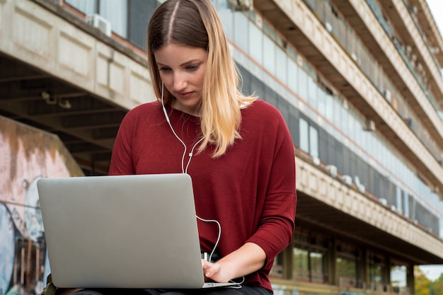 Jonge student die laptop in openlucht met behulp van.