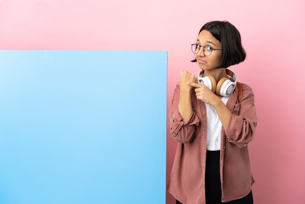 Jonge student gemengd ras vrouw met een grote banner over geïsoleerde achtergrond die het gebaar maakt van te laat te zijn