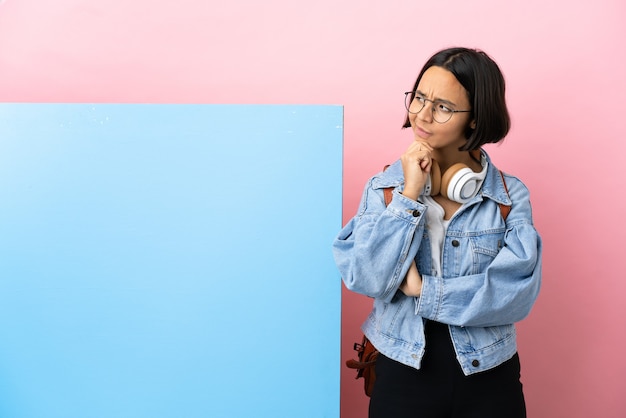 Jonge student gemengd ras vrouw met een grote banner over geïsoleerde achtergrond en opzoeken