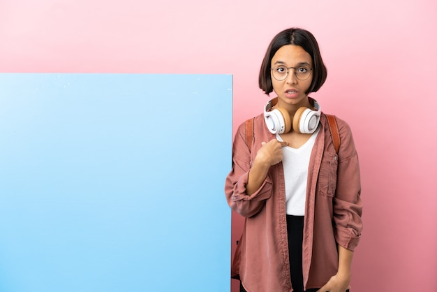 Jonge student gemengd ras vrouw met een grote banner over geïsoleerde achtergrond naar zichzelf te wijzen