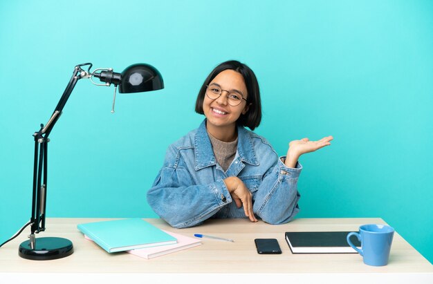 Jonge student gemengd ras vrouw studeren aan een tafel met een idee terwijl op zoek naar glimlachen