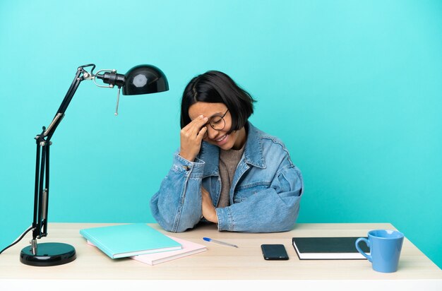 Jonge student gemengd ras vrouw studeren een tafel lachen