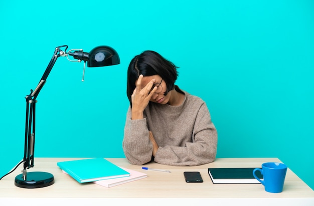 Jonge student gemengd ras vrouw studeren op een tafel met hoofdpijn