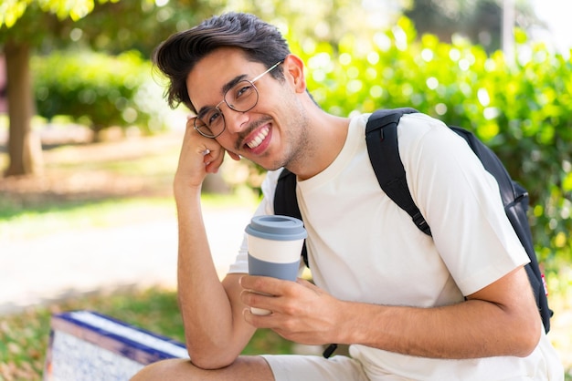 Jonge student man in de buitenlucht met een afhaalkoffie