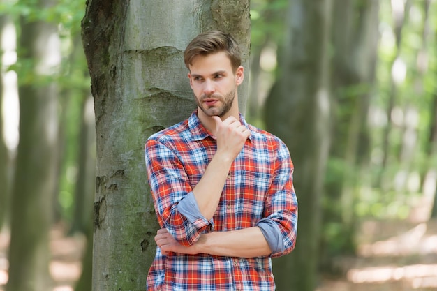 Jonge student man in geruit hemd buiten, casual mode.