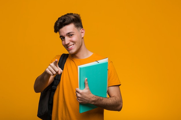 Jonge student man met boeken schreeuwen opgewonden naar voren.