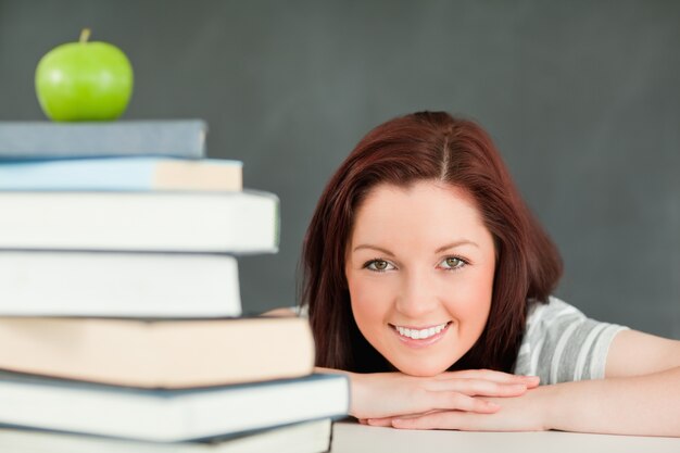 Jonge student met een appel en boeken op de voorgrond