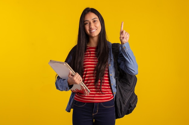 Jonge student met rugzak en boeken in studiofoto