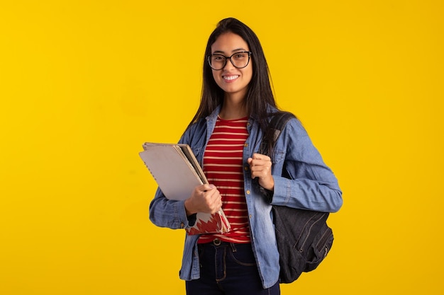 Jonge student met rugzak en boeken in studiofoto