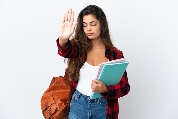 Jonge student vrouw geïsoleerd op een witte achtergrond stop gebaar maken en teleurgesteld