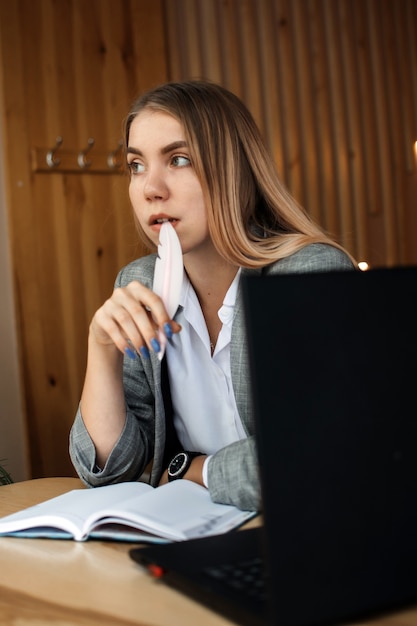 Jonge studente zit in café met laptop smartphone en kopje koffie student die online leert