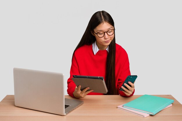 Jonge studenten Aziatische vrouw op een werkplek met een laptop geïsoleerd