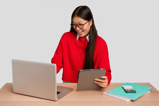 Jonge studenten Aziatische vrouw op een werkplek met een laptop geïsoleerd