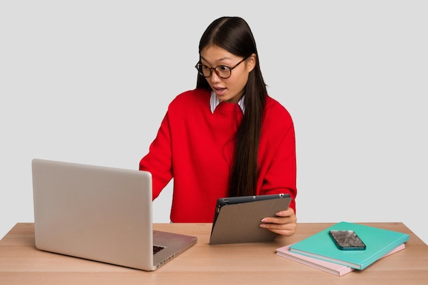 Jonge studenten Aziatische vrouw op een werkplek met een laptop geïsoleerd