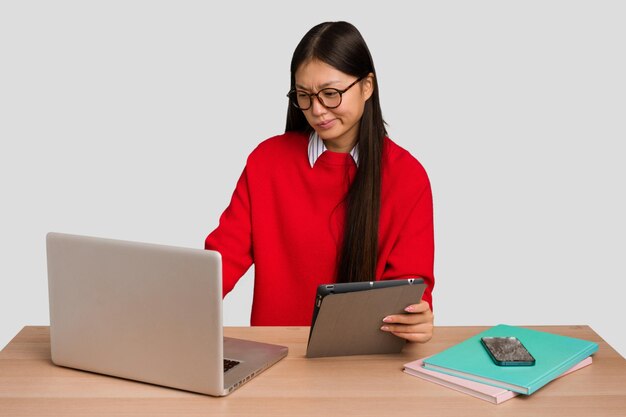 Jonge studenten Aziatische vrouw op een werkplek met een laptop geïsoleerd