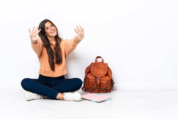 Jonge studenten Braziliaanse vrouw zittend op de vloer tien tellen met vingers