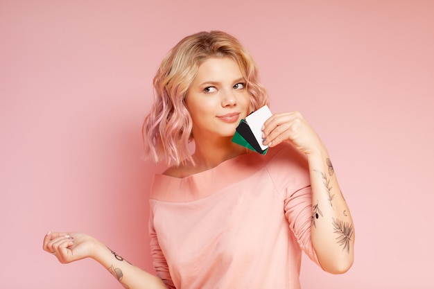 Jonge studenten hipster vrouw met gekleurde haren en tattoo holding creditcards