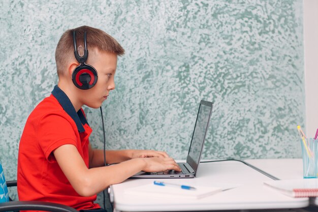 Jonge studentenjongen met laptop het leren