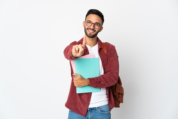 Jonge studentenmens die op witte achtergrond wordt geïsoleerd die en een vinger opheft