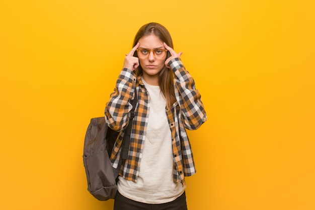 Jonge studentenvrouw die een concentratiegebaar doet