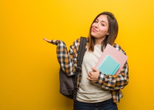 Jonge studentenvrouw die en schouders twijfelen ophalen