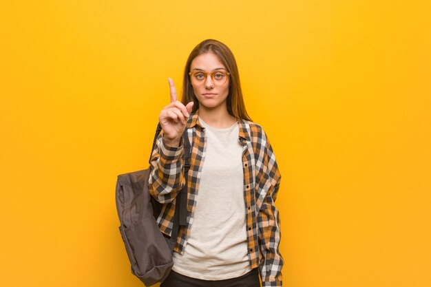 Jonge studentenvrouw die nummer één toont